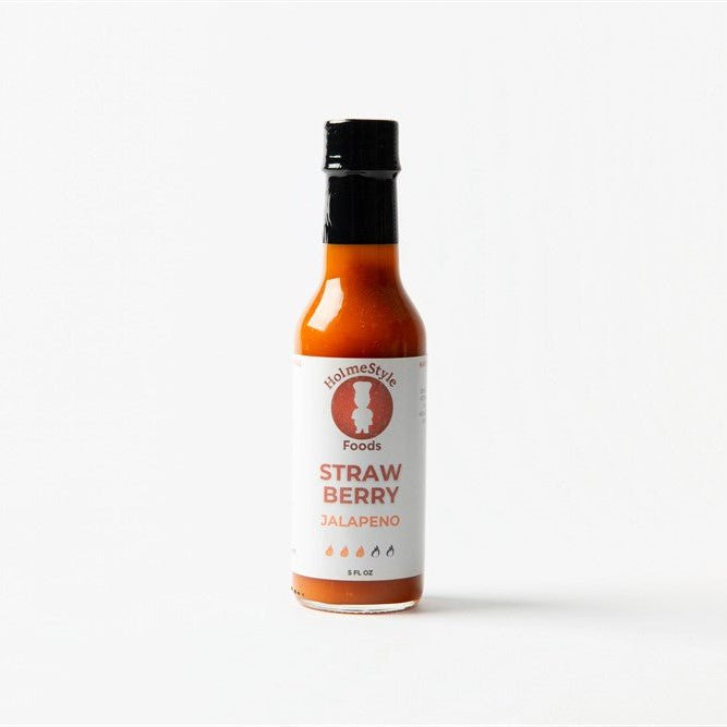 Bottle of Holmestyle Foods Strawberry Jalapeno hot sauce on a white background