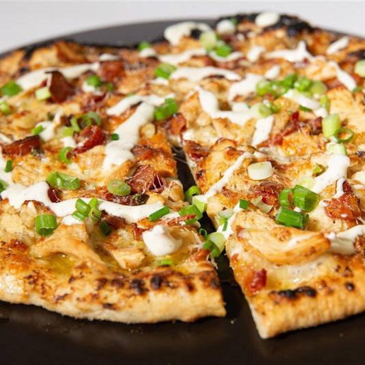 Grilled Pizza with bacon, cheese and green onions on a pan