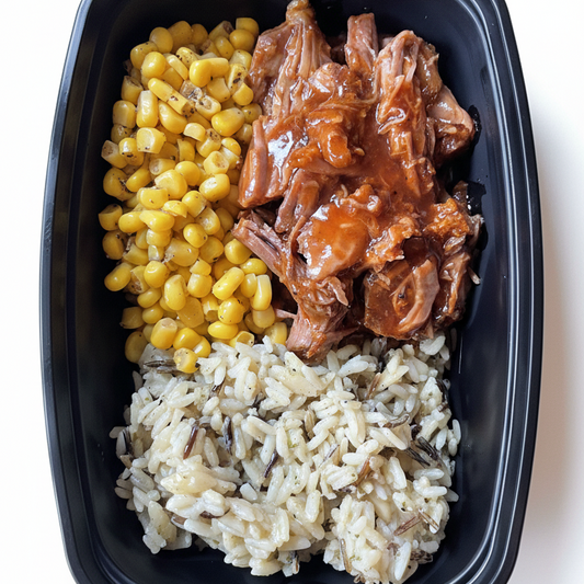 Black meal prep container with rice, corn, and pulled pork on a white background