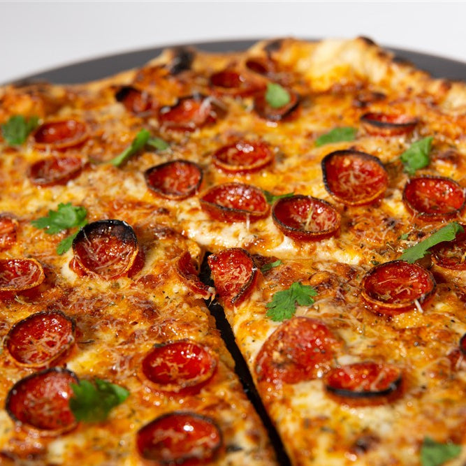 Pepperoni pizza with a slice cut out on a white background