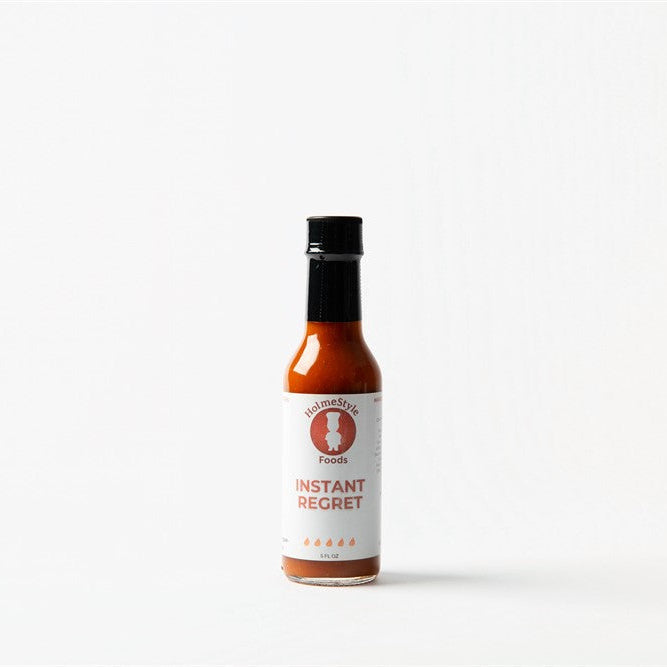 Bottle of Instant Regret hot sauce on a white background