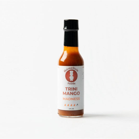 Bottle of Trini Mango Madness hot sauce on a white background